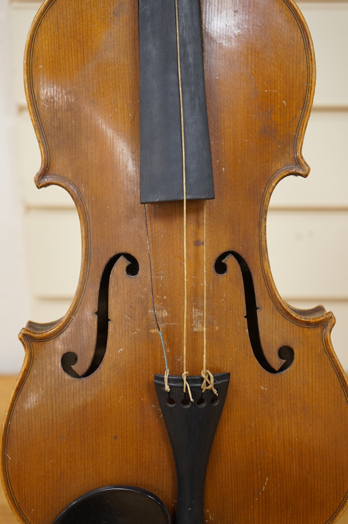 Three cased violins; a German Dresden violin, supplied by Campbell and co., Glasgow, together with another Dresden Stradivarius copy, and the remains of a European violin.
